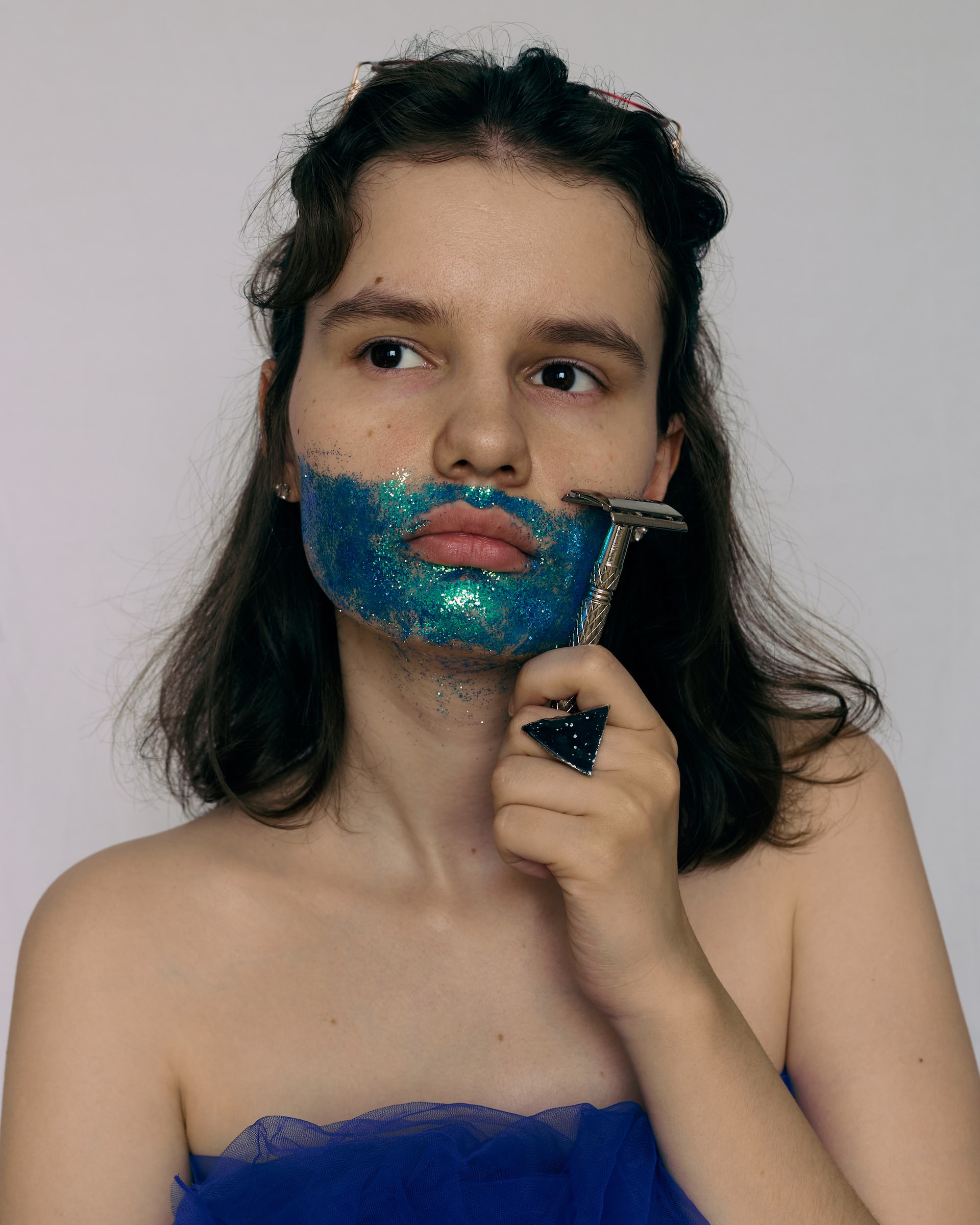 young-woman-shaving-blue-glitter-off-her-face