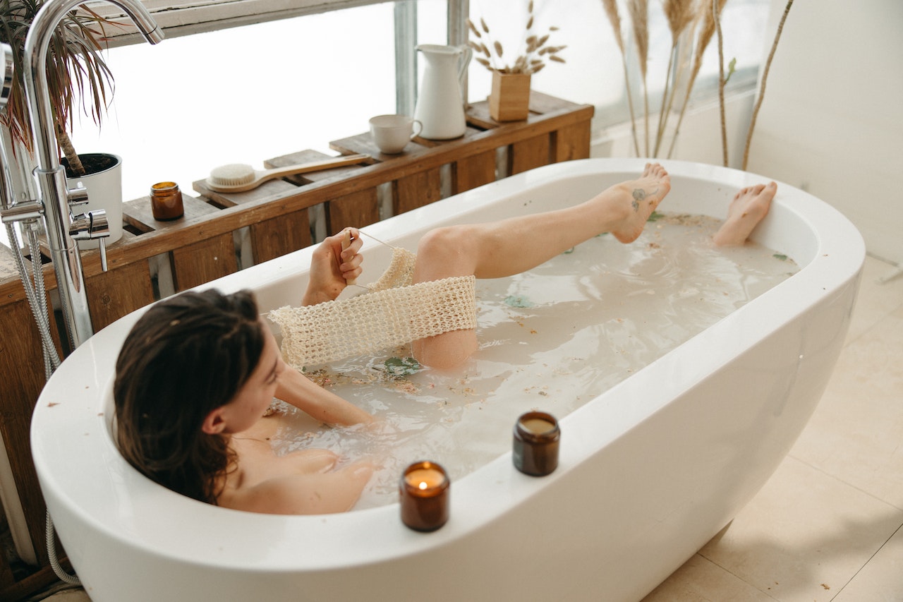 woman-in.bathtub-exfoliating-her-legs