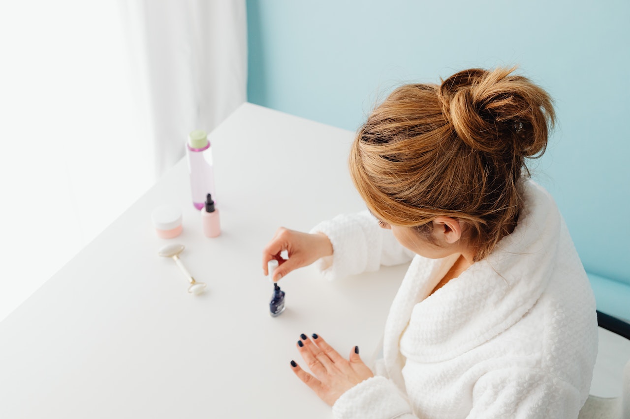 Woman-in-bathrobe-painting-her-nails