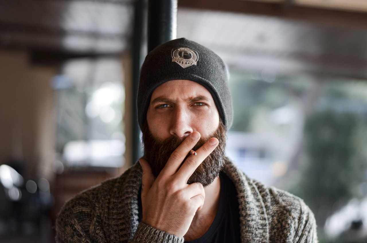 man with thick beard smoking