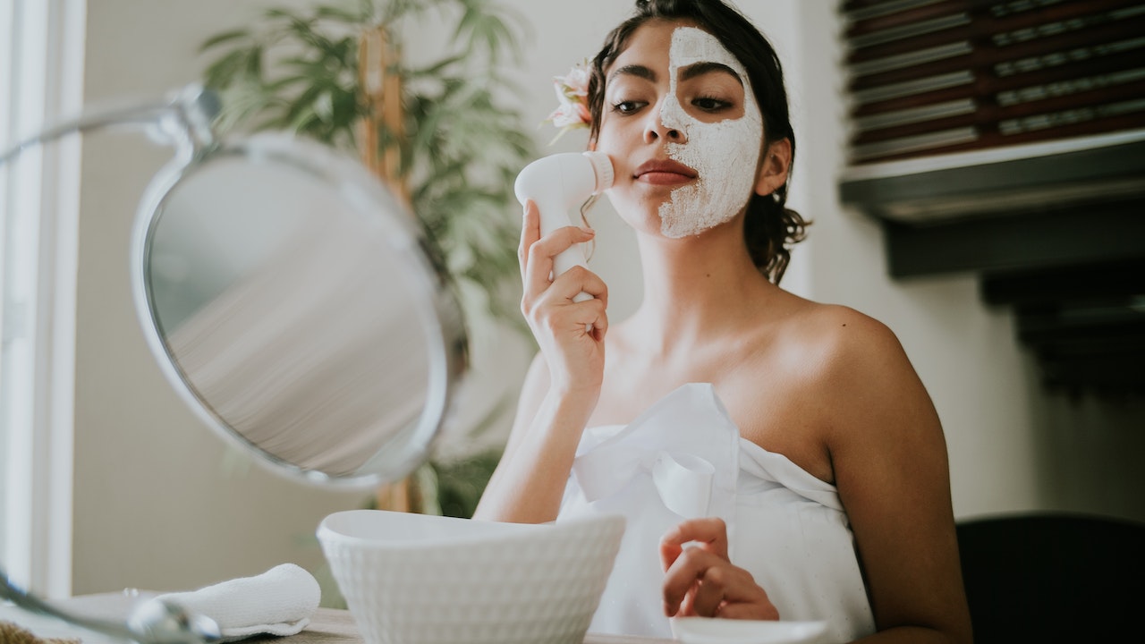 woman using cleanser products to remove her makeup