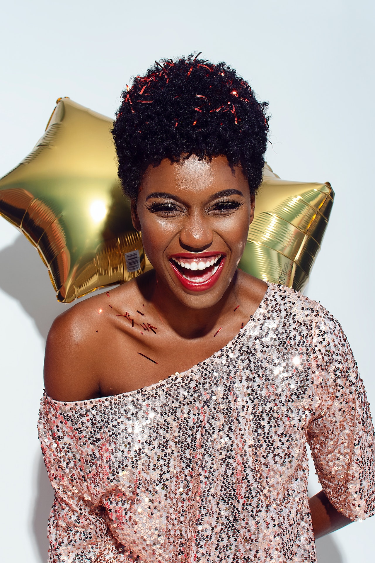 happy woman celebrating new year with a golden ballon behind her