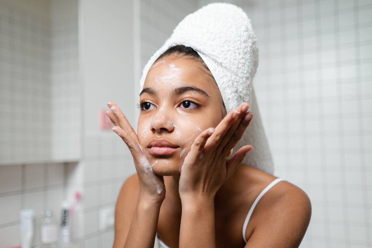 Woman-in-White-Tank-Top-Washing-Her-Face-With-Soap