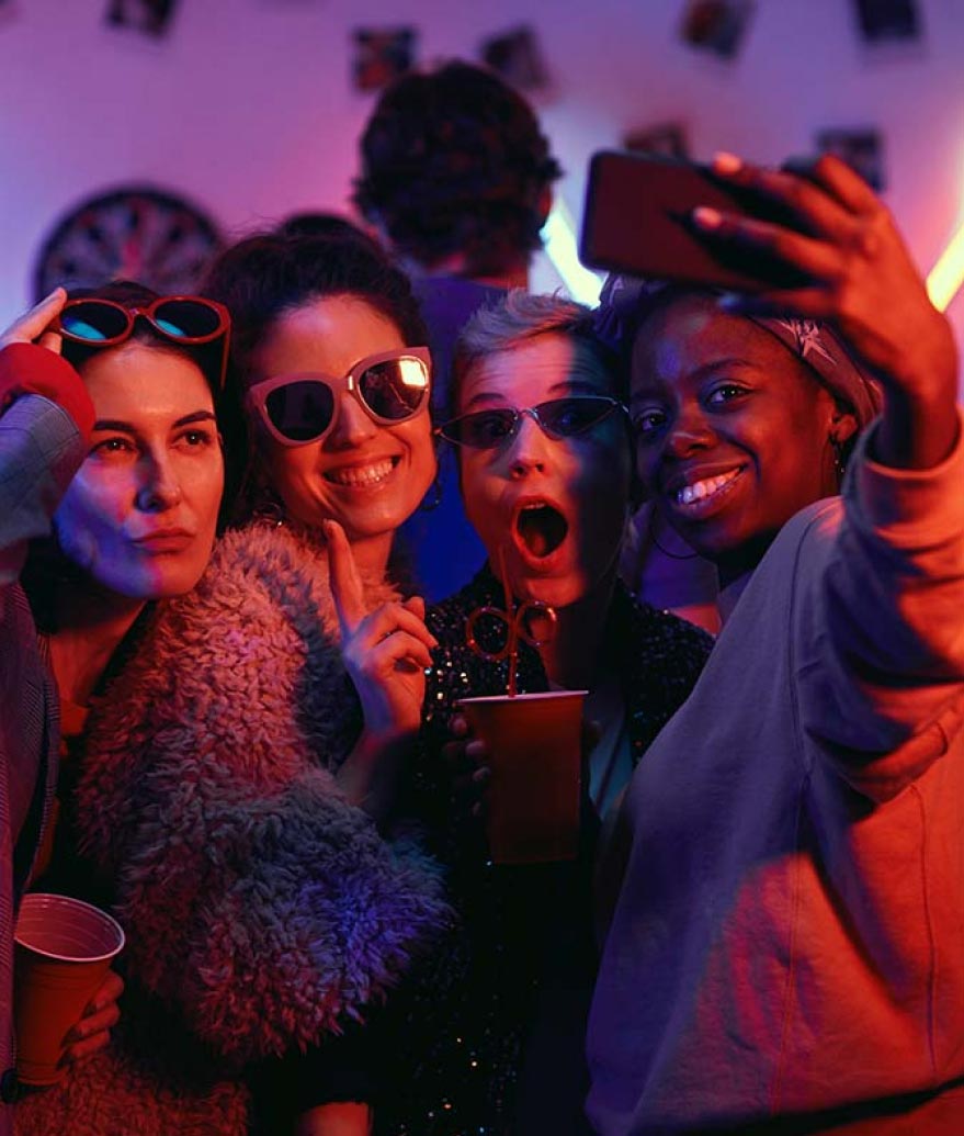 A group of 4 young adults smiling while taking a selfie