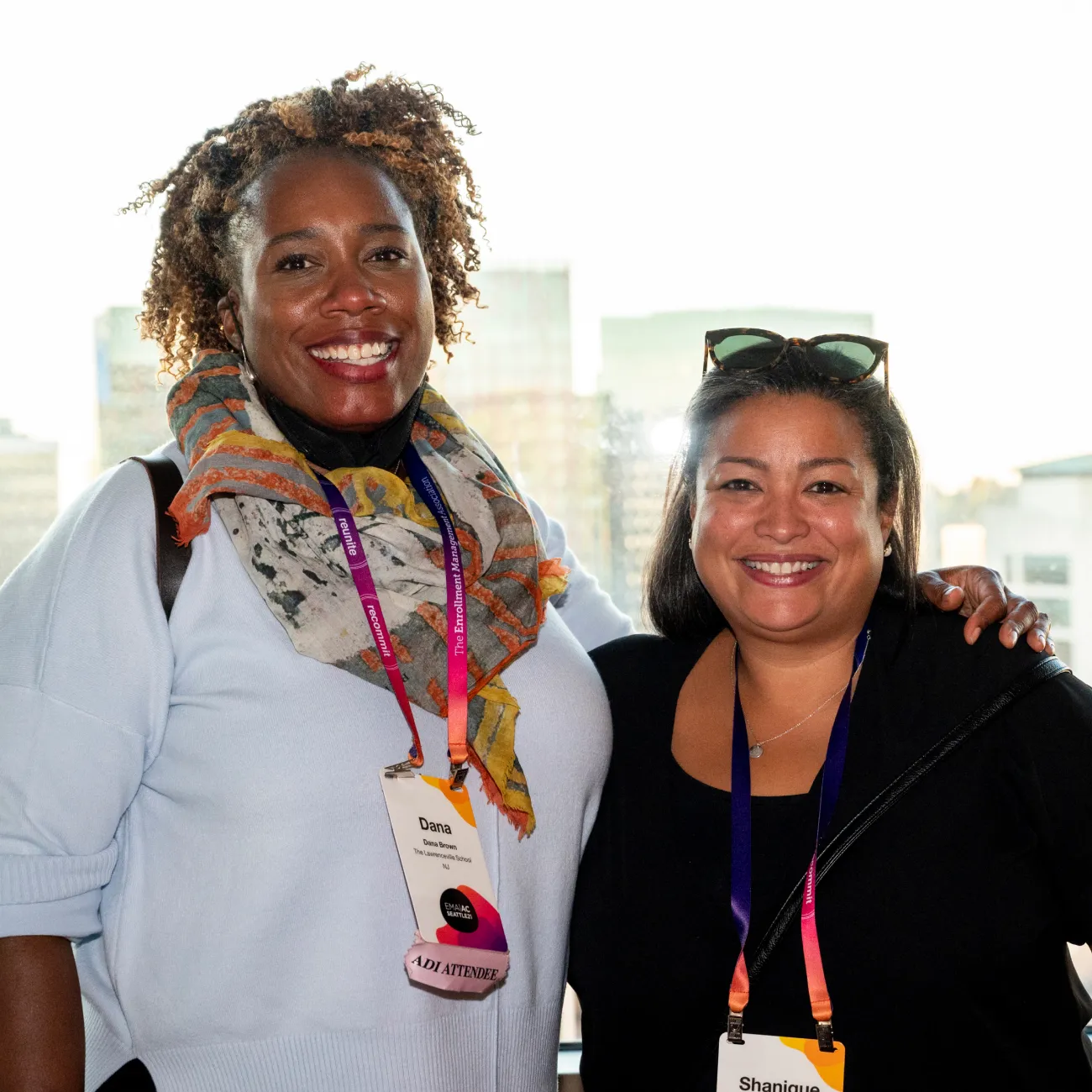 Two female EMA members posing for a photo with the Seattle skyline behind them.