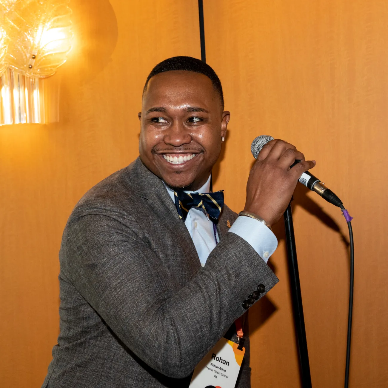 An EMA member grabbing the mic at a reception with a fun, devilish smile on his face.