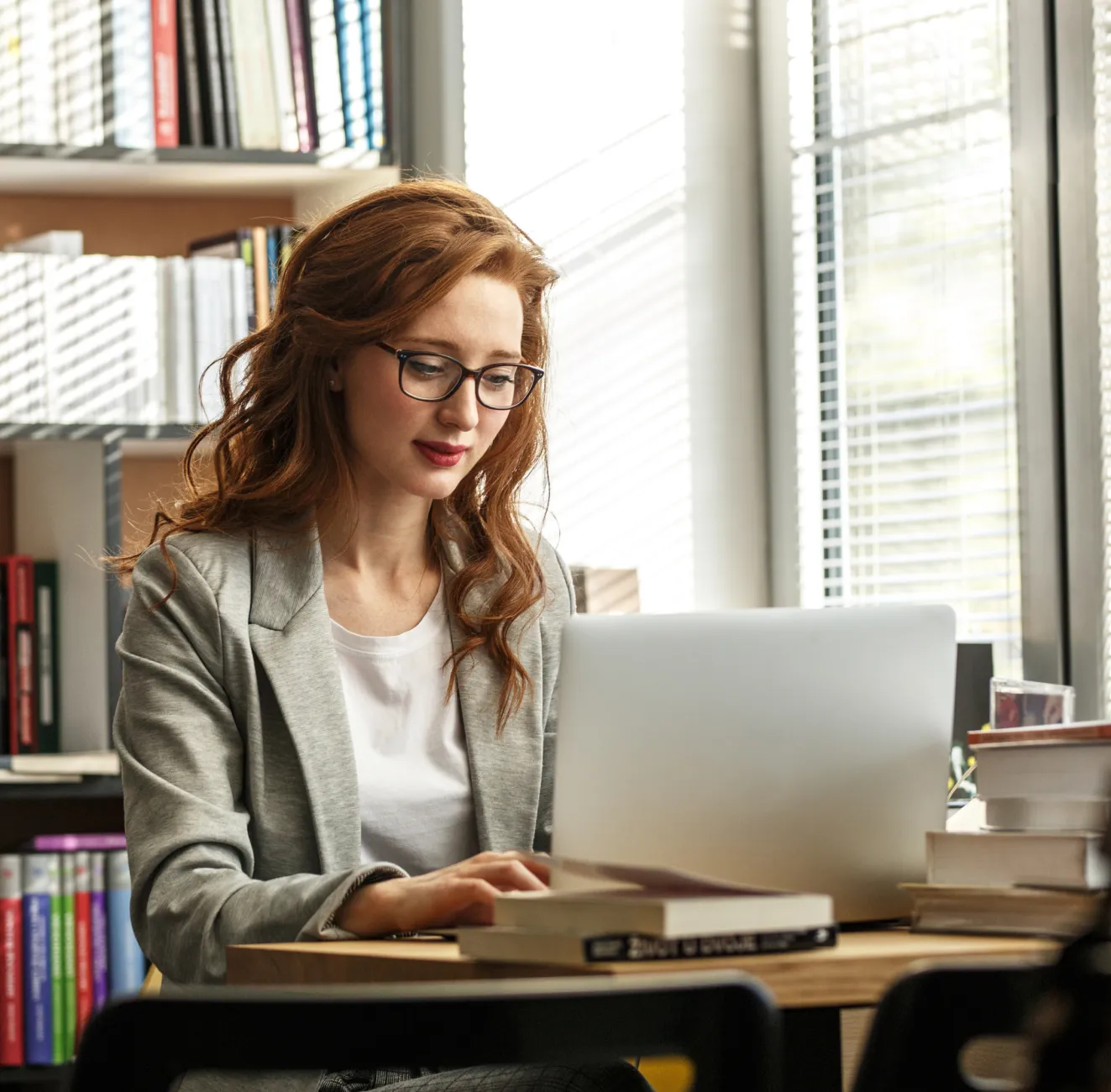A woman writing an article for EMA on her laptop.