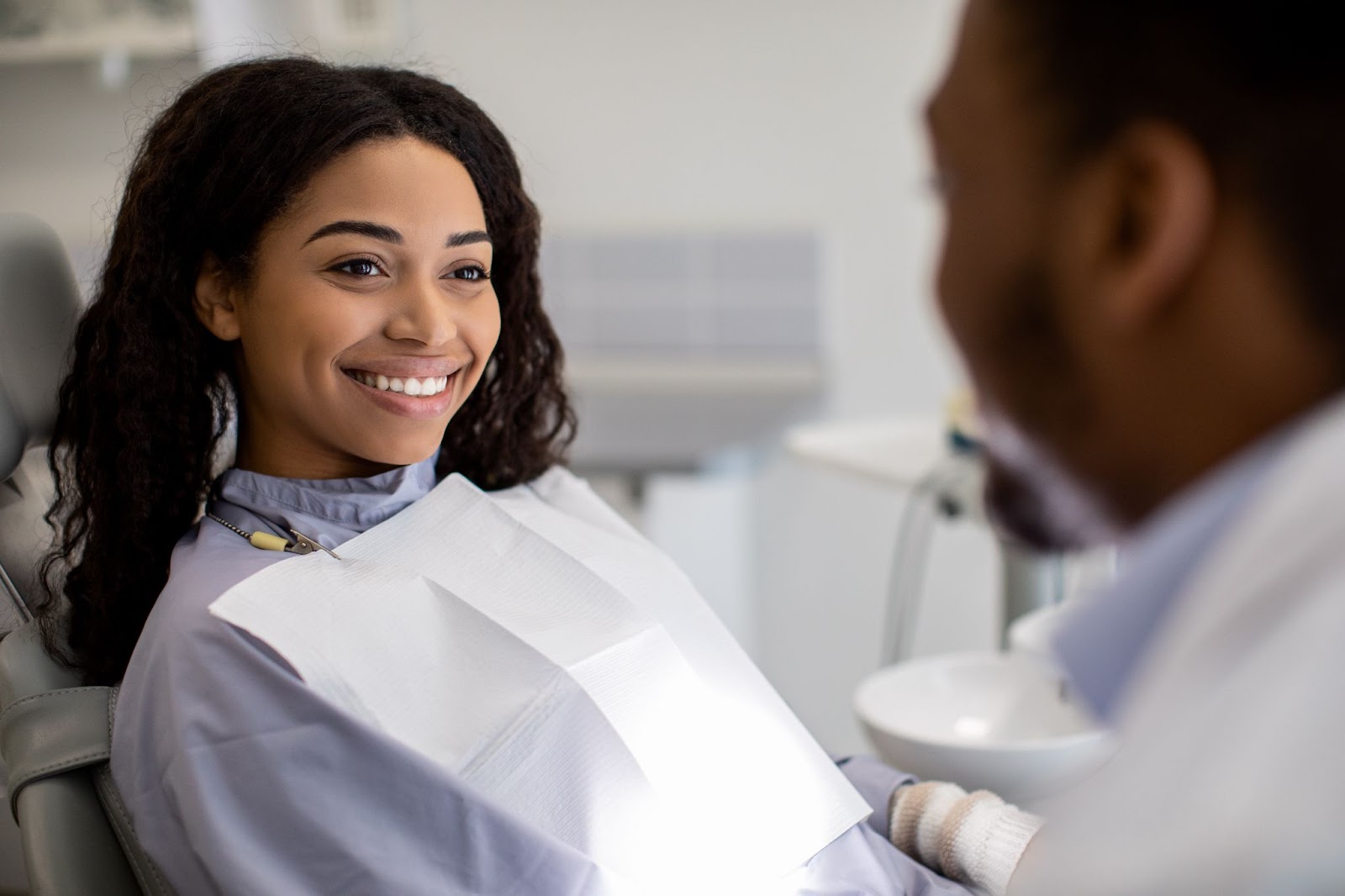 a new patient talks to the dentist at their first visit