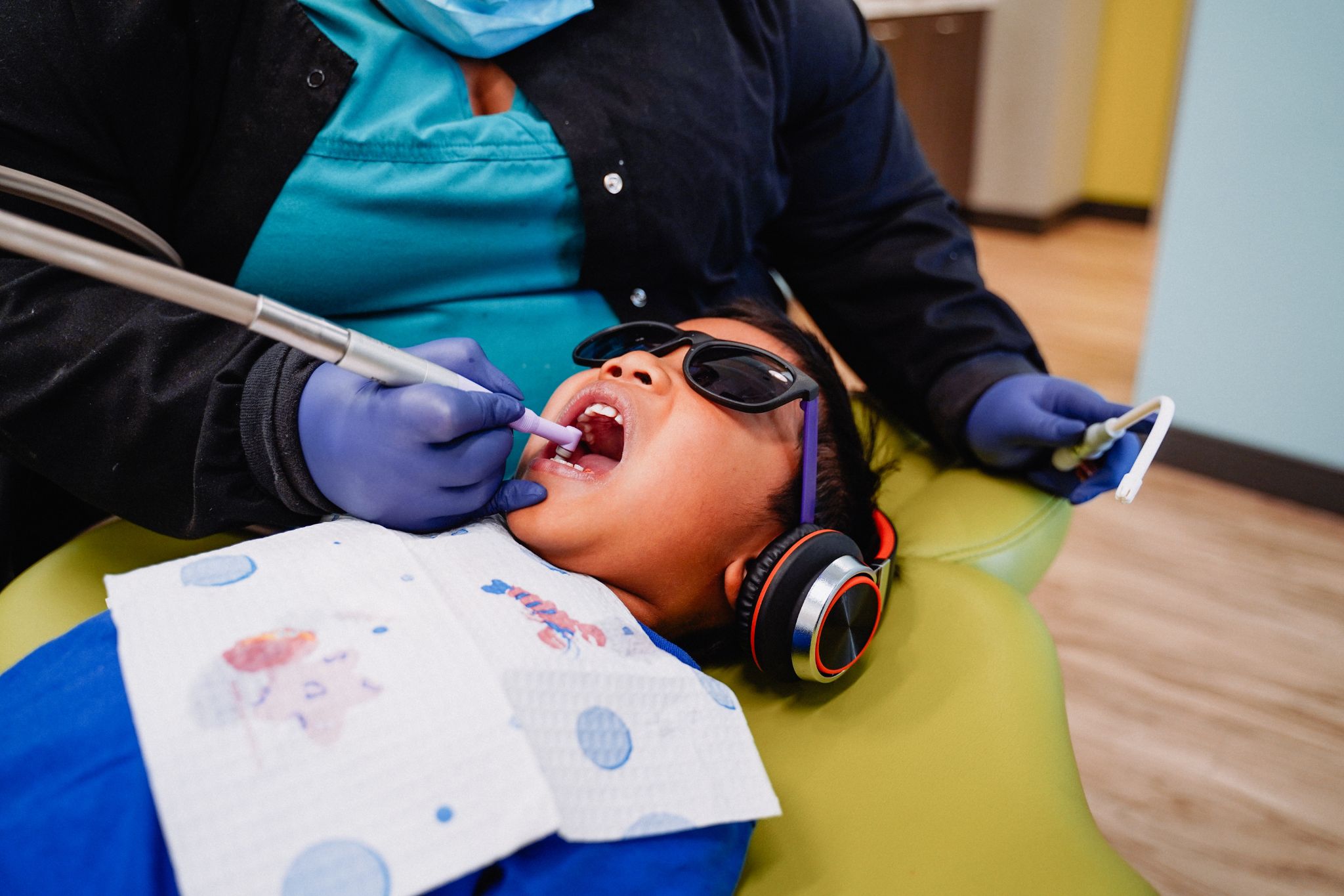 patient at a pediatric dental office getting their teeth polished