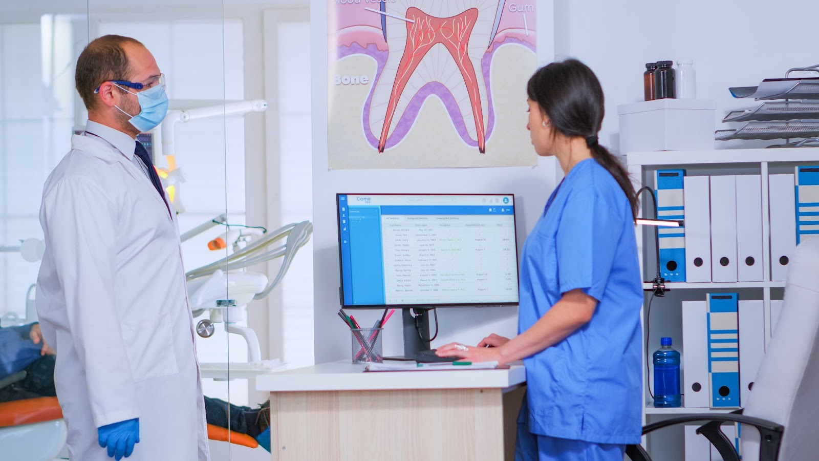 dental staff chat near an office computer