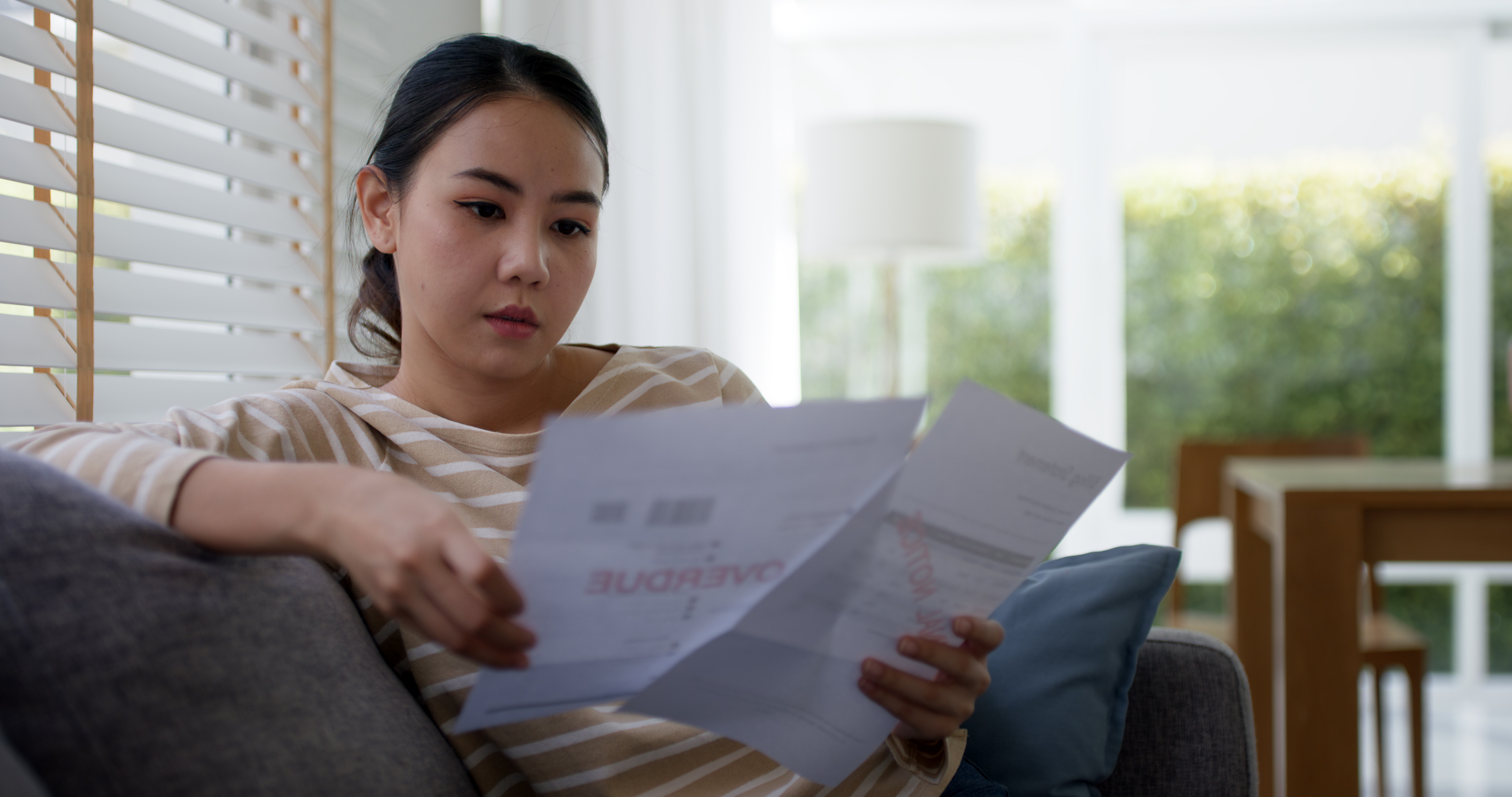 woman looking at past-due bills