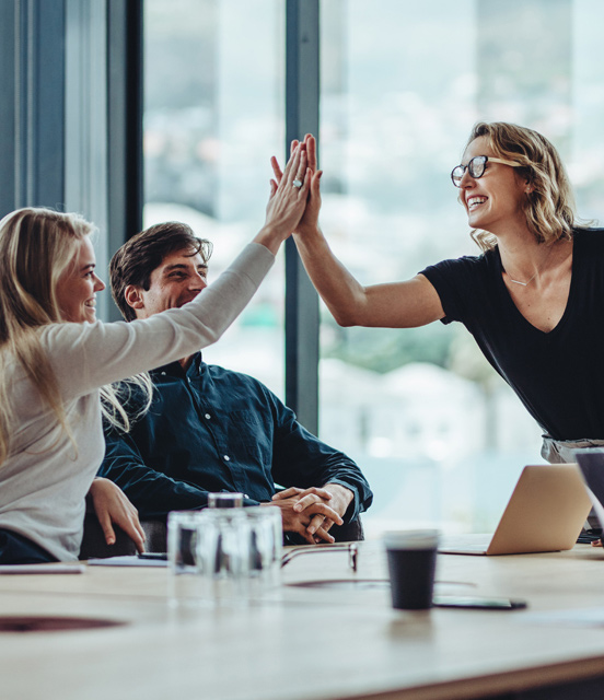 Coworkers high fiving during meeting