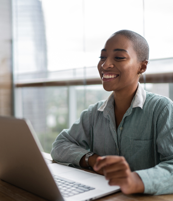 Smiling woman staring at laptop