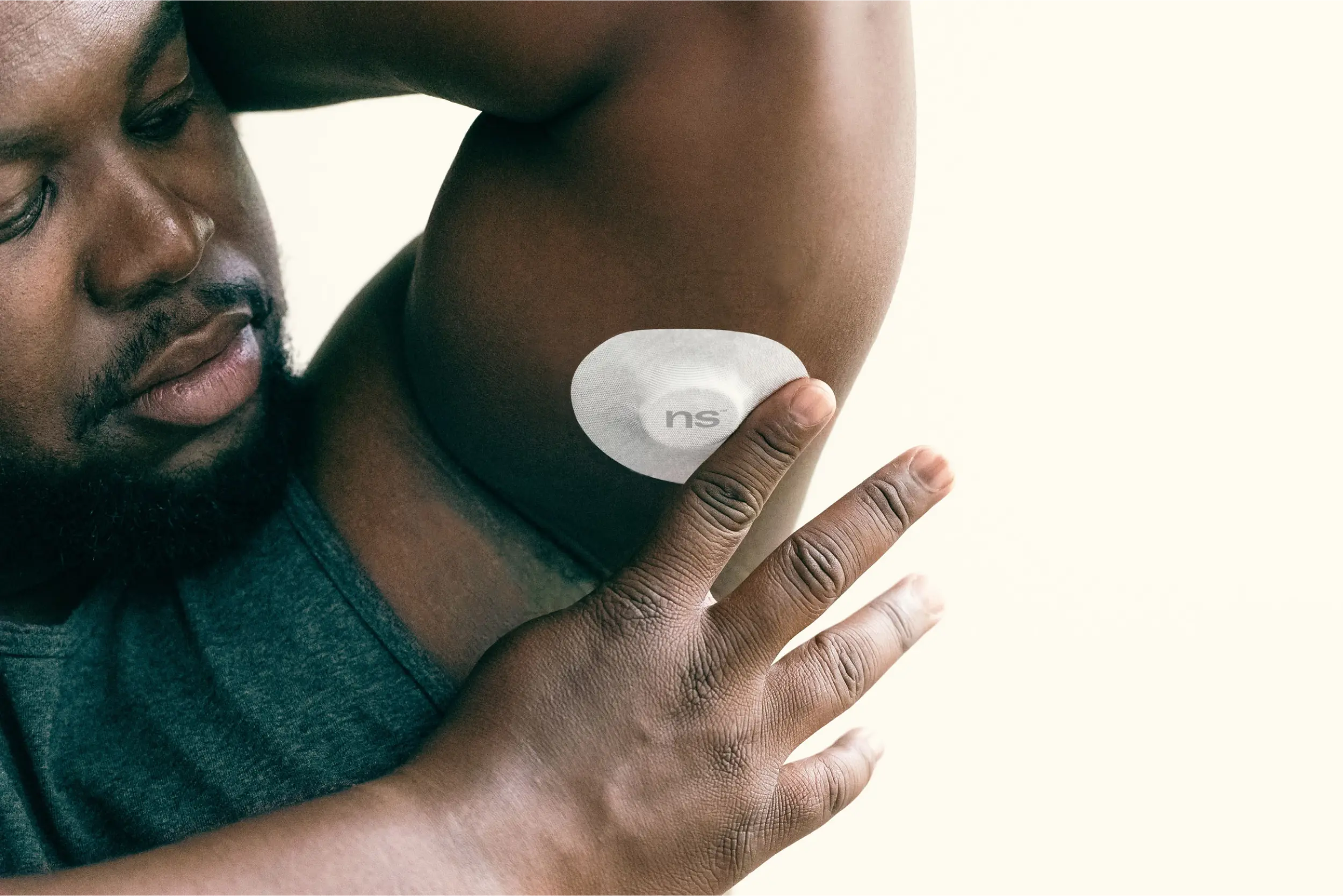 A man placing Nutrisense patch on his inner side of left upper hand.