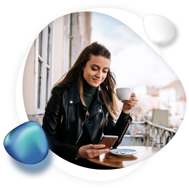 Young professional drinking coffee and scrolling her mobile device