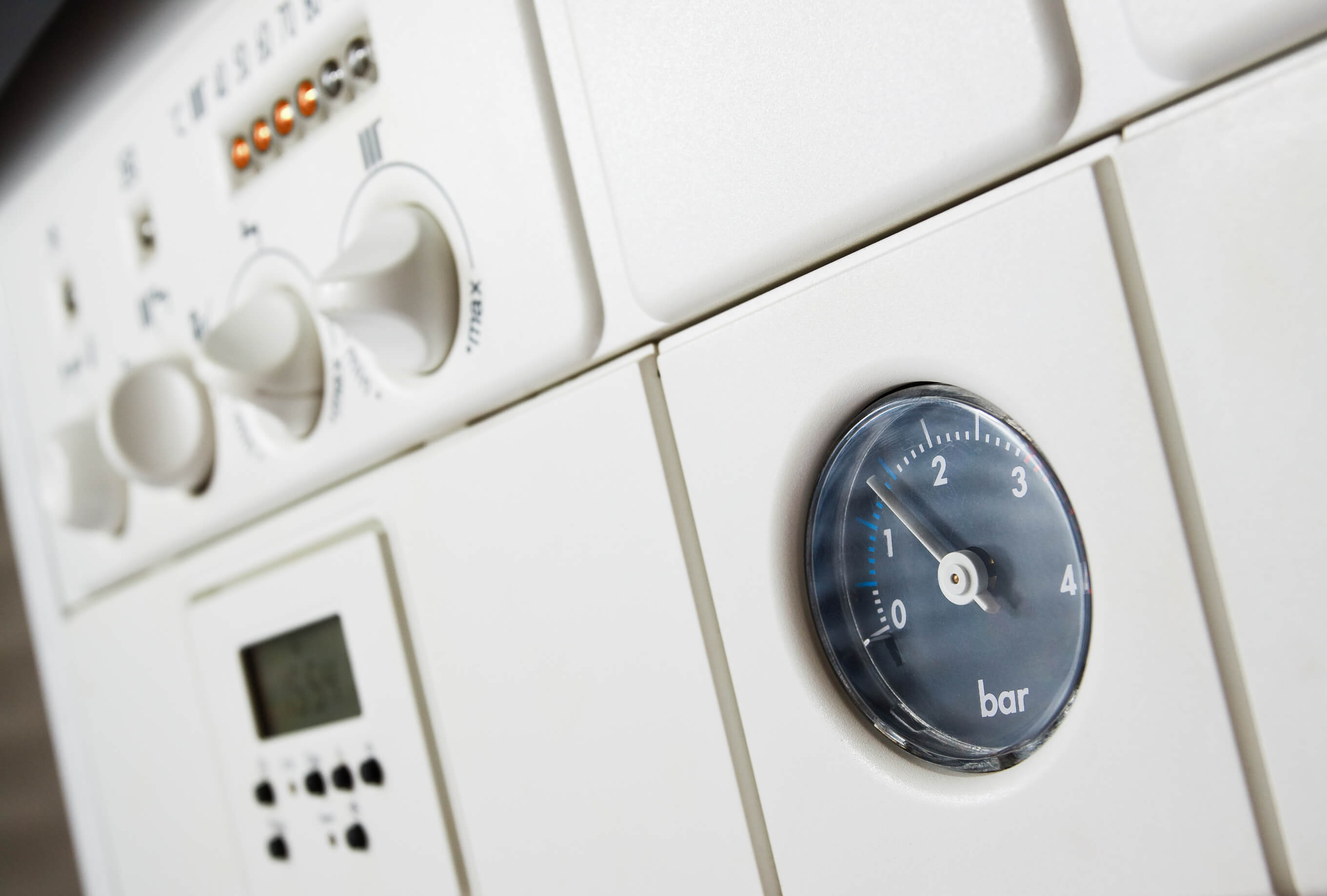 Black pressure gauge on a white boiler