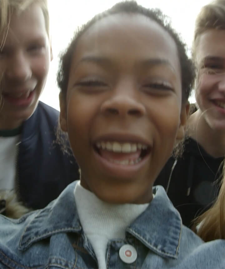 Teenagers circling around the camera and laughing