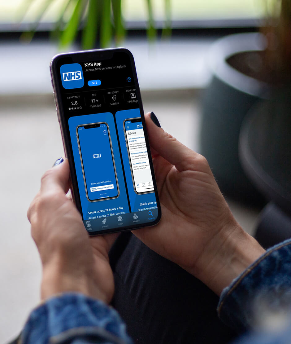 Female hands holding an iPhone about to download the NHSx app