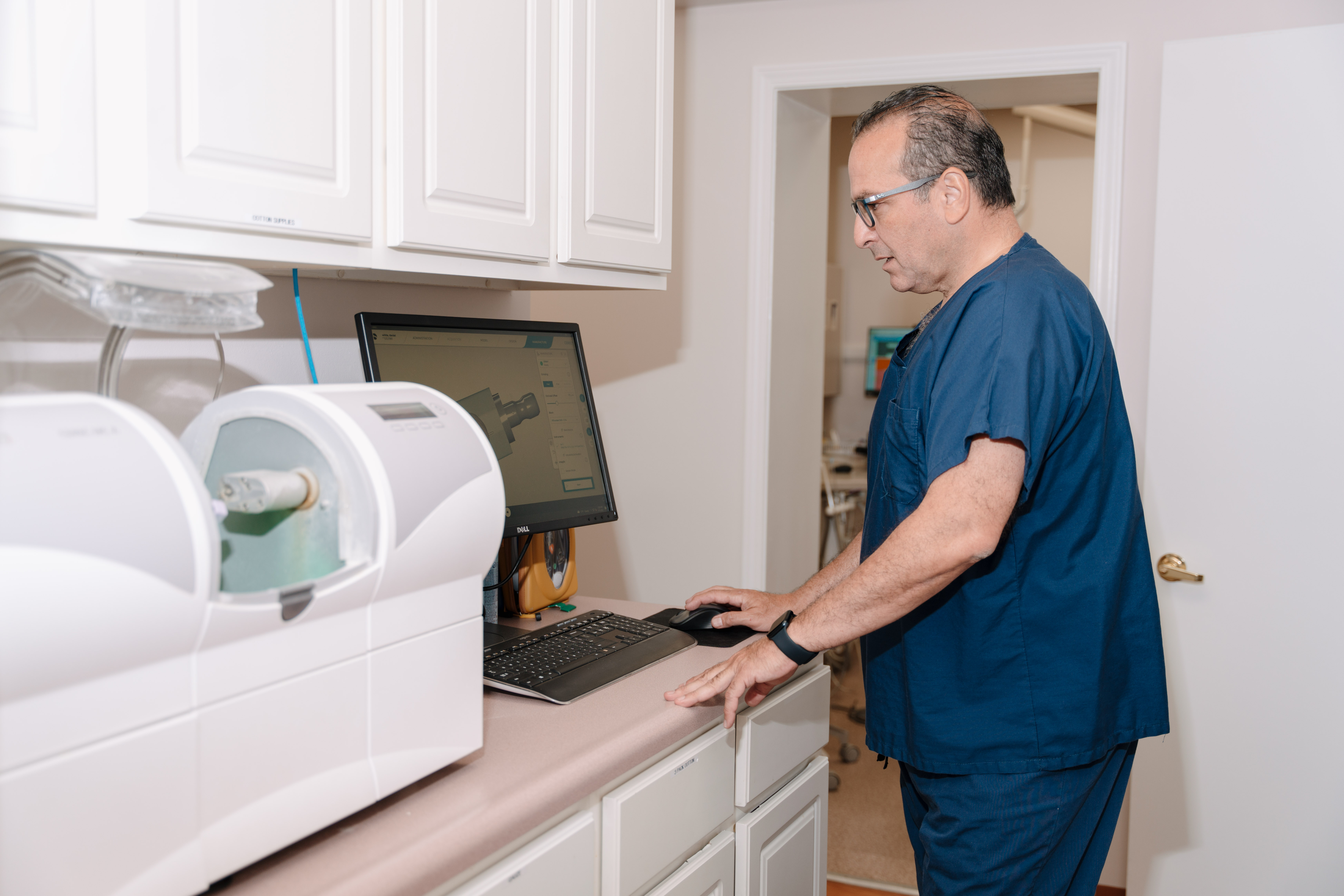 A male dentist using a computer to design dental implants