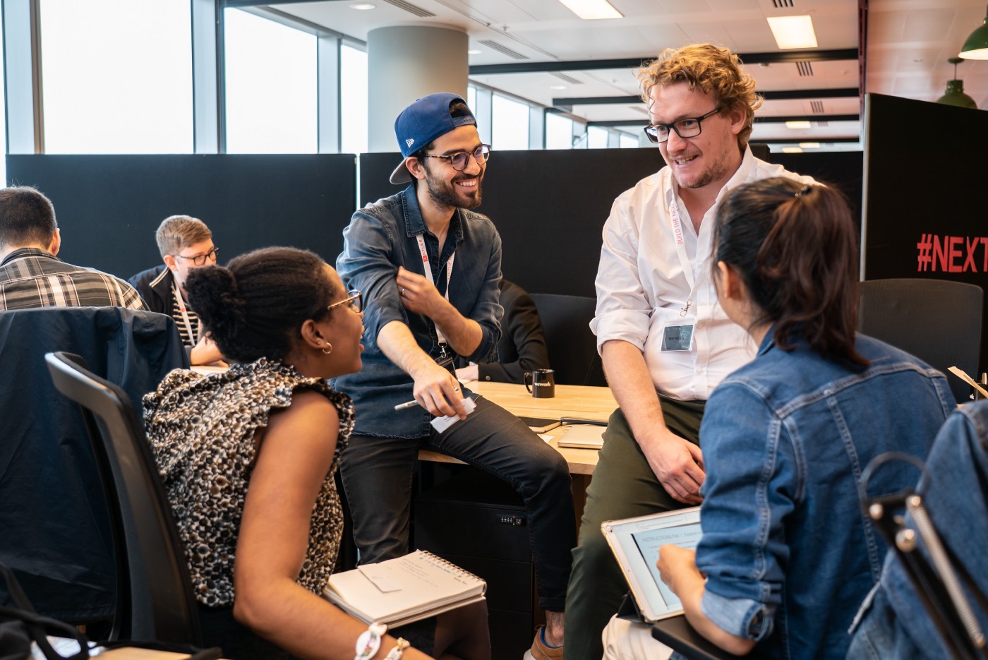 Group of our sitting having discussion with two people sitting on table and two on chairs