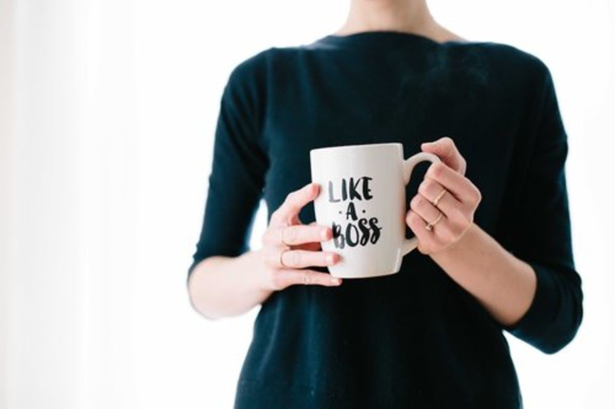 Image of white coffee cup with the words "Like a boss" being held by woman
