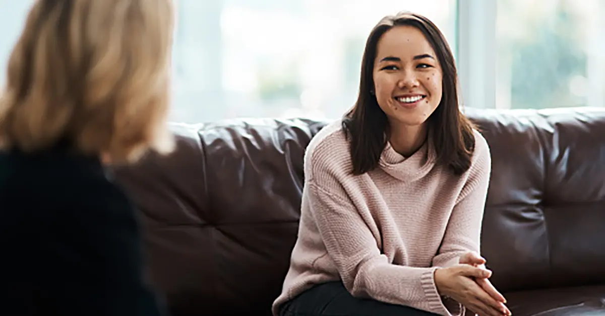 Teen sitting on a couch talking to a therapist