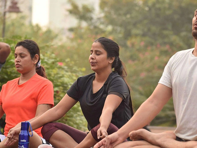 Three individuals meditating in a group therapy session