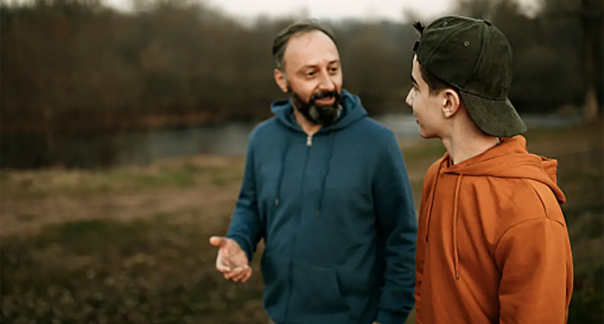 Father and son having a talk while on a walk in the park