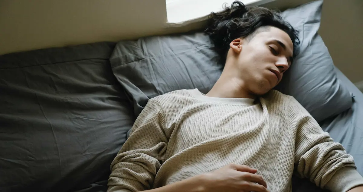 teen laying in bed suffering from anxiety