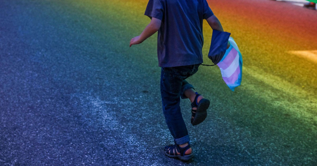 Transgender child running with a transgender flag