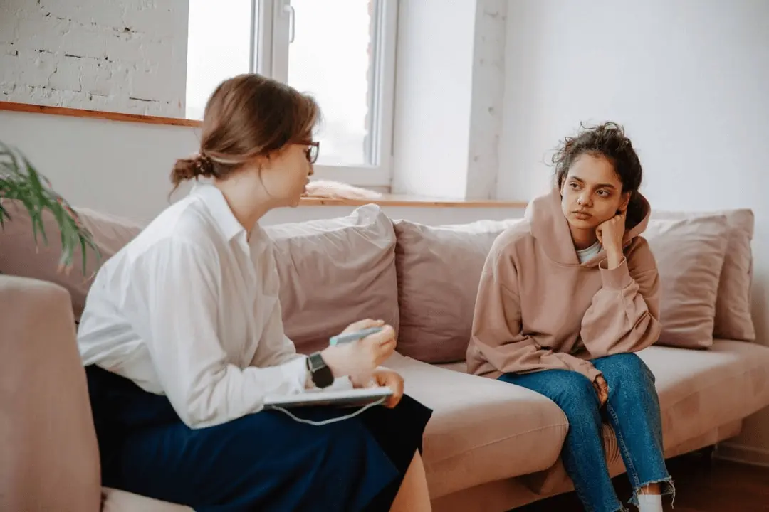 A female teen with depression talks with a therapist