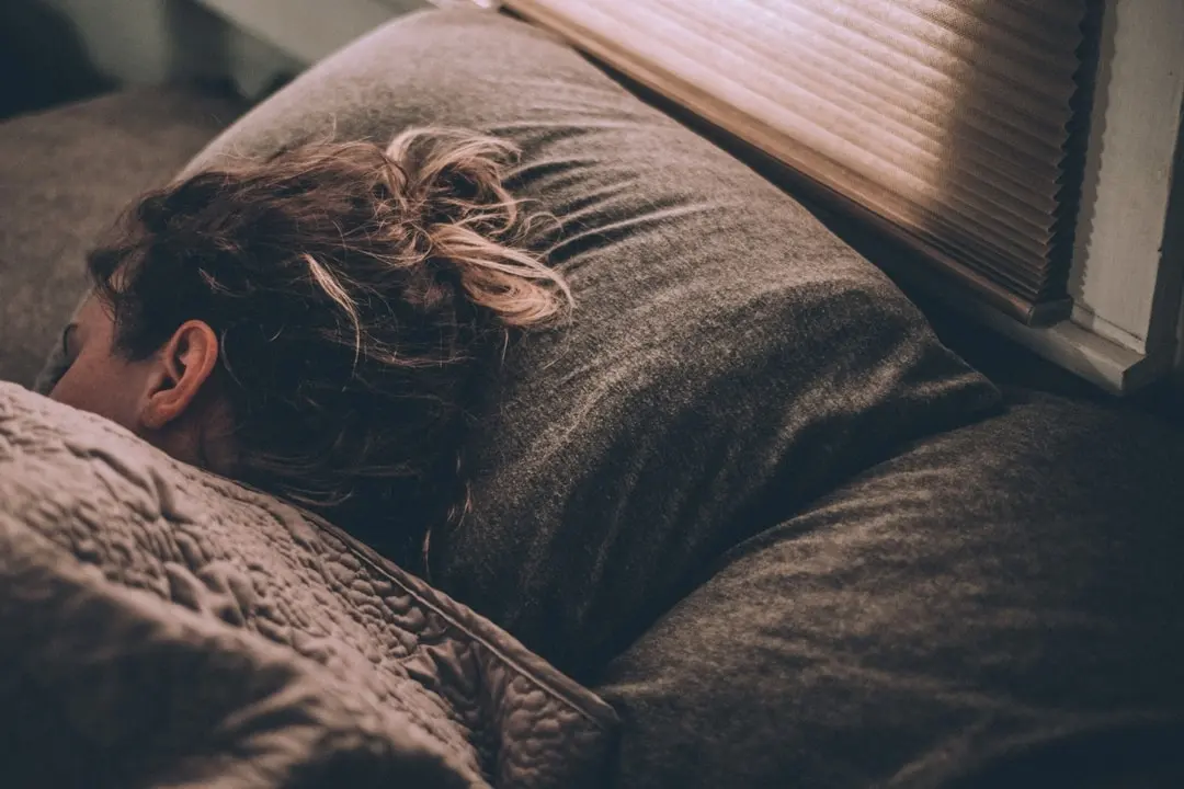 A teen sleeps in a dim room to help with their mental health