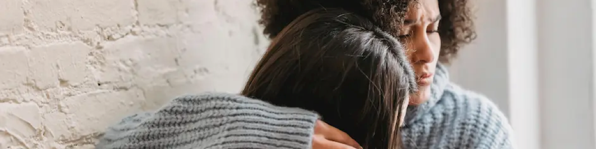 Parent hugs teen in pain
