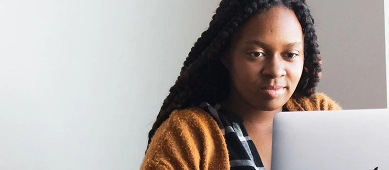 teenage girl taking part in online therapy on her computer