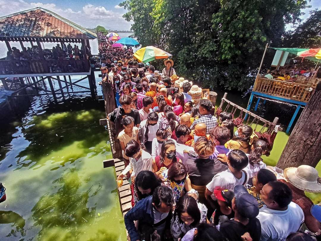 a crowd of domestic visitors at U Bein Bridge(Mandalay) on the full moon day of War-So