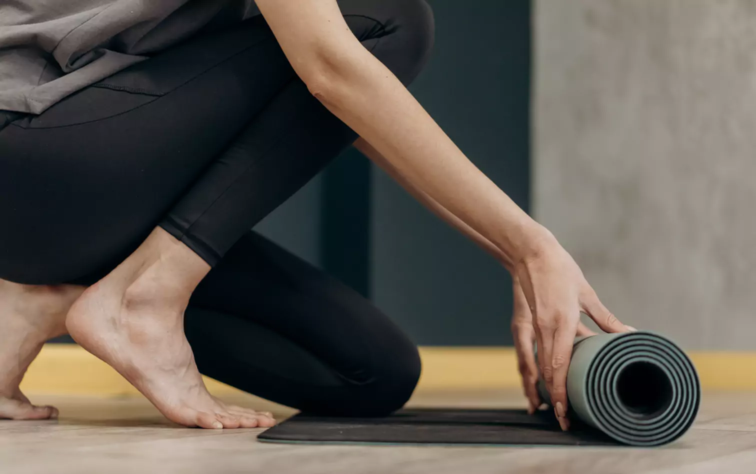 a person rolling yoga mat