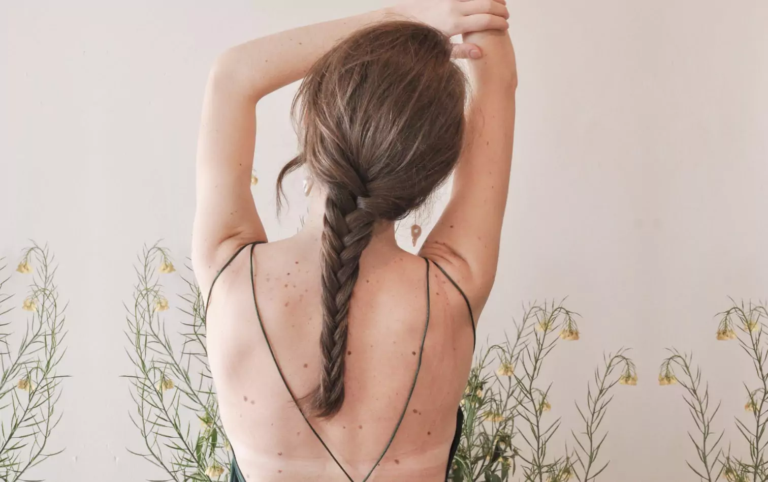 A woman in a plait with her back turned, stretching