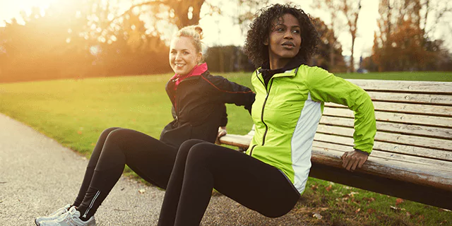 two people doing reverse push-ups outdoors
