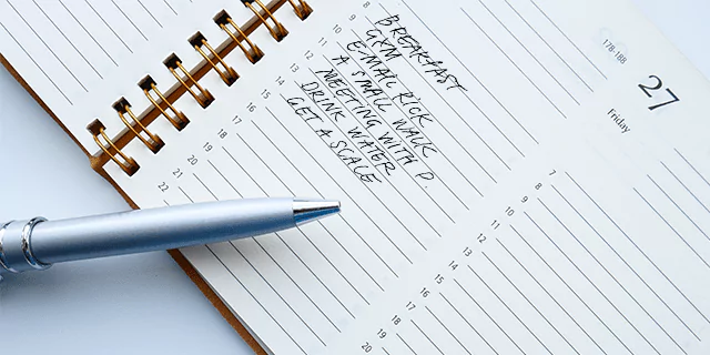 a person making notes on a journal