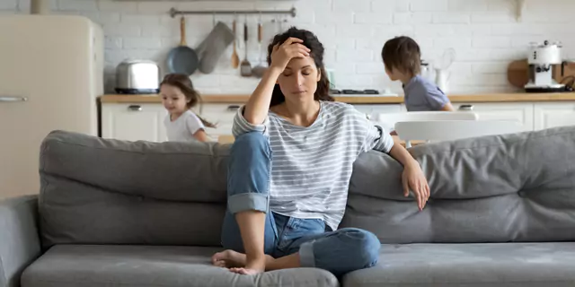a person sitting on a sofa, looking stressed out