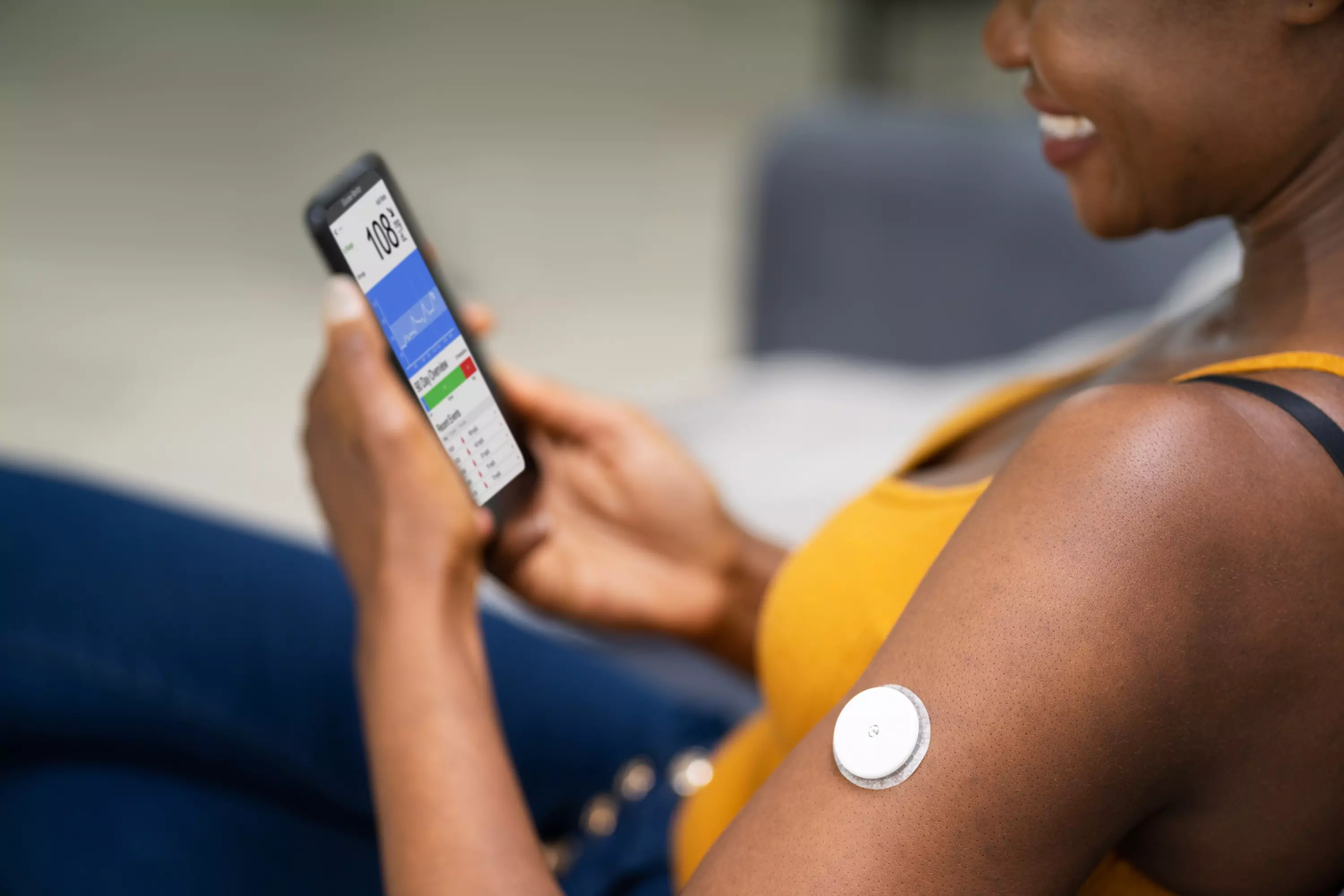 a person wearing CGM and looking at their glucose chart