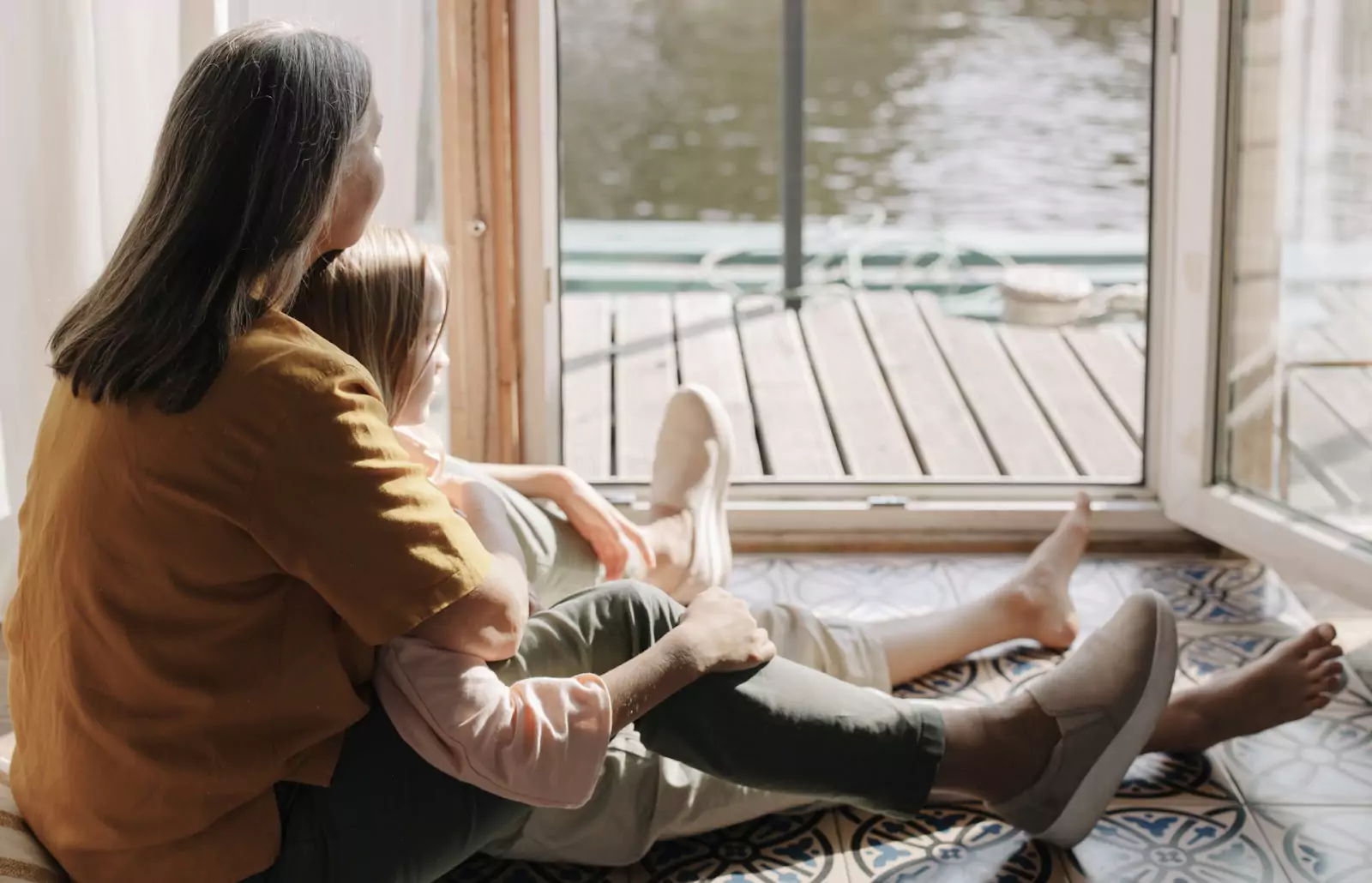 an older person and a kid sitting near an open door