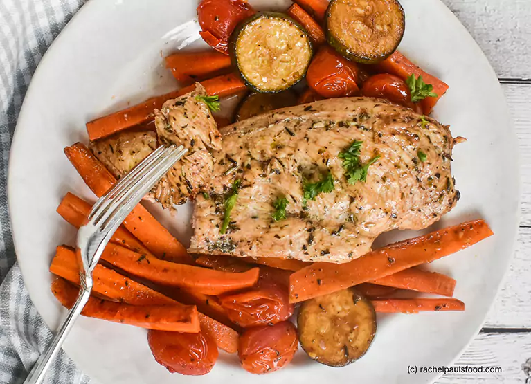 Plate of chicken breast with zucchini, carrots, and tomatoes
