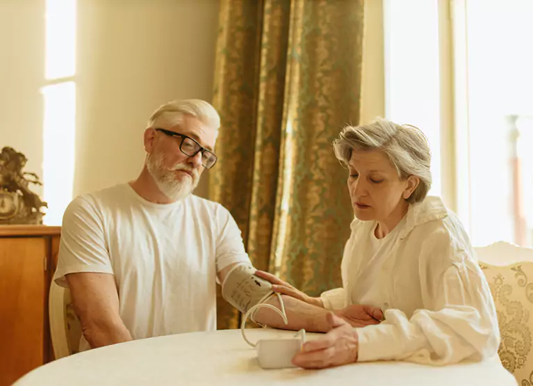 two older adults checking blood pressure