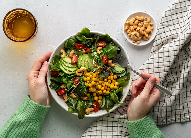 a salad bowl with spinach, avocado, and chickpeas