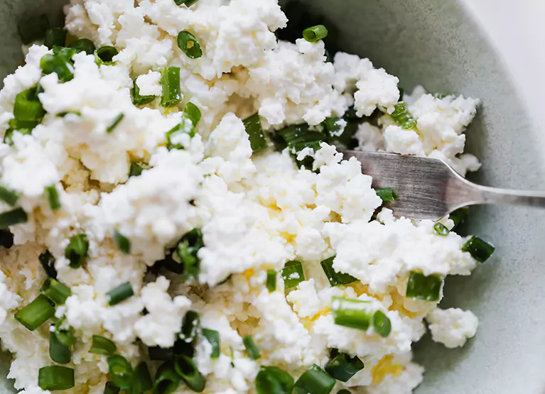 a plate filled with scallions and cheese