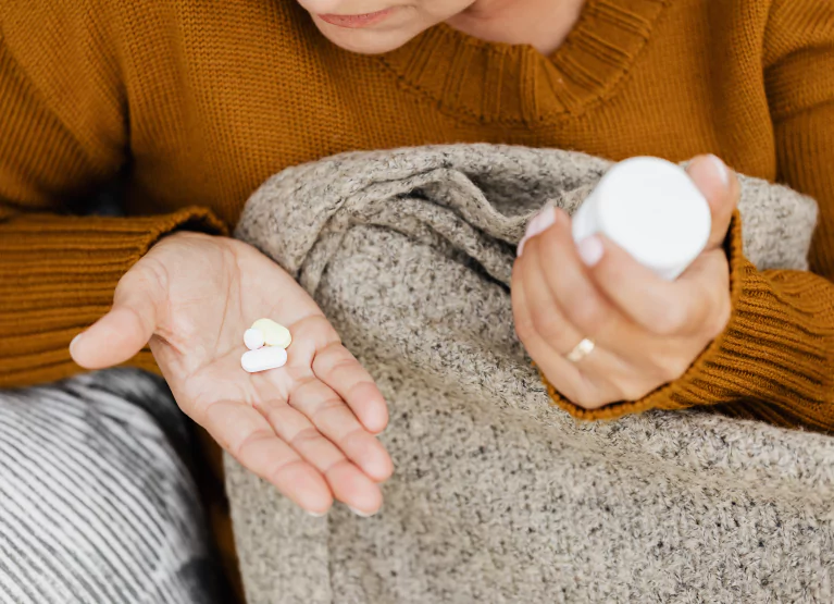 a girl holding a bottle of pills in her hand