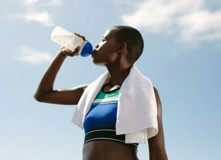a girl drinking water after a workout