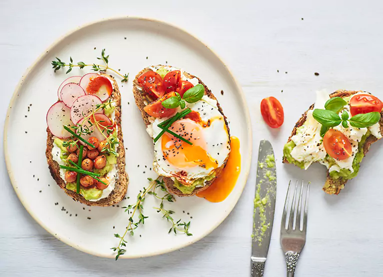 Avocado toast with chia seeds, tomatoes, radishes, and herbs