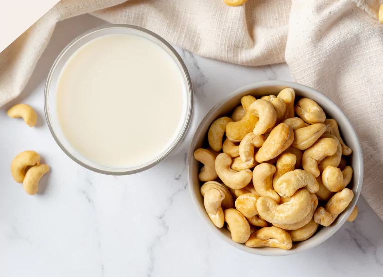 bowl of cashew and glass of cashew milk